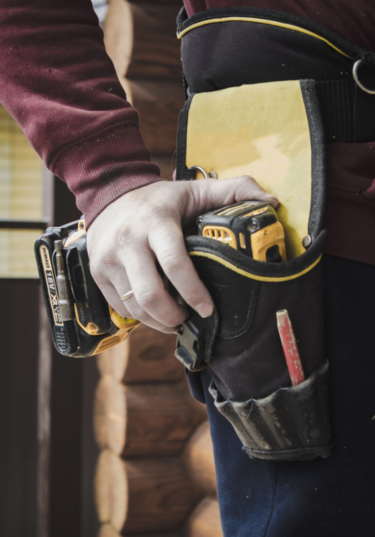 Hand on dewalt drill in toolbelt